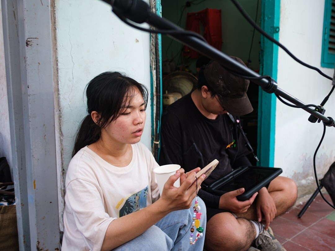 Person doing mobile live streaming with smartphone and microphone